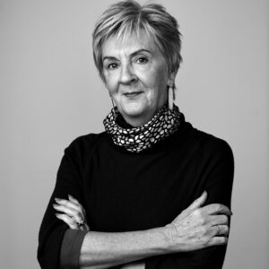 Facilitator Di van Meegen standing in front of a grey wall